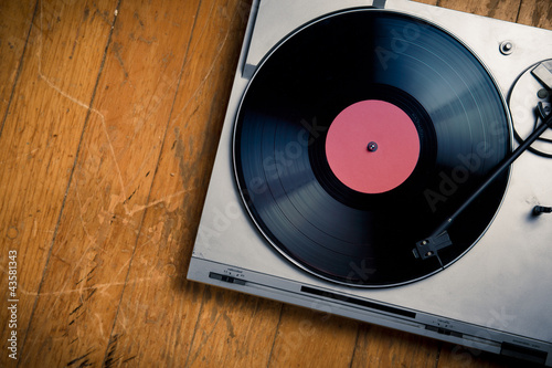 Photo: Vintage turntable with disc on wood Vintage turntable with disc on wood