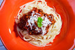 Tagliatelle Bolognese auf einer roten Teller
