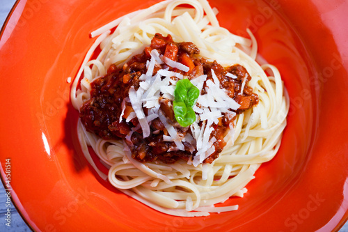 Foto: Tagliatelle Bolognese auf einer roten Teller Tagliatelle Bolognese auf einer roten Teller