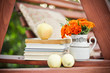 Books, fresh apples, and marigolds in a vase stock image