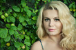 Foto: Beautiful blonde woman next to apple tree with selective focus Beautiful blonde woman next to apple tree with selective focus