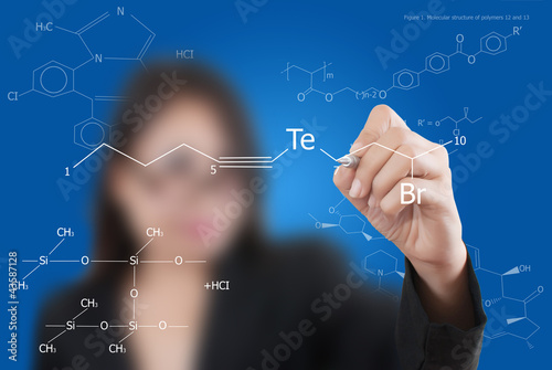 Photo: Teacher lady writing scientific formula on the whiteboard. Teacher lady writing scientific formula on the whiteboard.