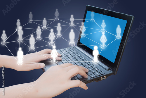 Photo: Hand pushing laptop keyboard with social network. Hand pushing laptop keyboard with social network.