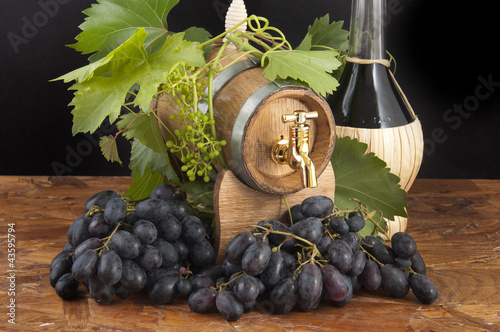 Foto: In oak casks with vines and grapes white and black In oak casks with vines and grapes white and black