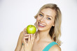 Attractive smiling young woman holding a green apple