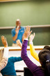Foto: group of students arms up in classroom group of students arms up in classroom
