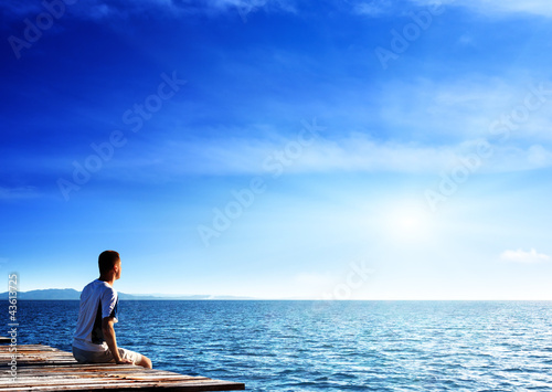 Foto: young man relax siting on pier young man relax siting on pier