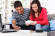 Photo: Smiling couple paying bills at home Smiling couple paying bills at home