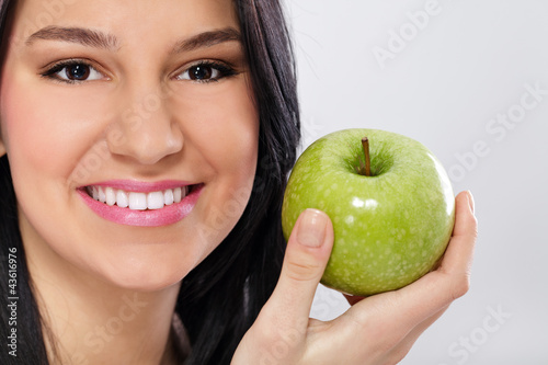Foto: Young smiling woman with apple Young smiling woman with apple