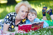 Senior woman reading book to her grandson