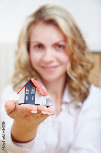 Photo: Frau hält Haus auf Hand Frau hält Haus auf Hand