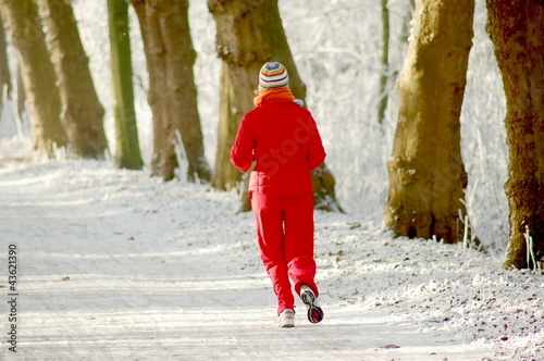 Photo: Joggerin auf einem verschneiten Waldweg Joggerin auf einem verschneiten Waldweg