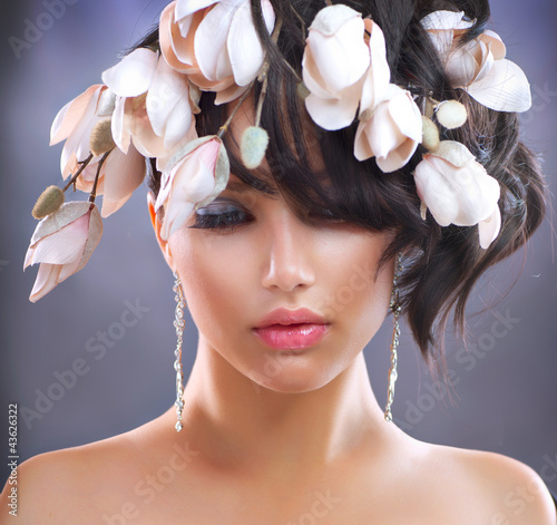 Photo: Fashion Brunette Girl with Magnolia Flowers. Hairstyle Fashion Brunette Girl with Magnolia Flowers. Hairstyle