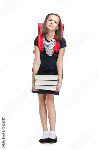 Photo: Schoolgirl with the briefcase and the pile of heavy books Schoolgirl with the briefcase and the pile of heavy books