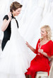 Shop assistant proposes a wedding dress to the bride
