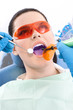 Dentist uses photopolymer lamp and dental mirror
