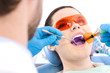 Dentist uses photopolymer lamp to cure carious teeth