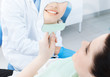 The patient admires her smile looking at the mirror