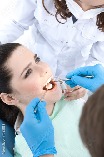 Photo: Dentist drills a carious tooth of the patient Dentist drills a carious tooth of the patient