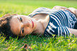 Closeup of a beautiful young woman lying in grass