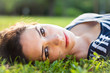 Closeup of a beautiful young woman lying in grass