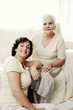 An old lady and her daughter flashing a smile at the camera