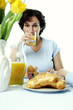 A woman drinking a glass of orange juice