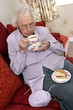 An old bespectacled woman stop knitting for her tea time