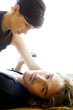 A guy lying on the floor with his girlfriend sitting on top of him