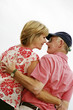 A married couple standing close to each other for a kiss