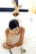 A lady lying forward on the bed with her legs up