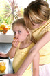 A woman watching her daughter eating lemon