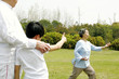 Foto: A boy giving his grandmother a thumb up for performing a good tai chi technique in the park A boy giving his grandmother a thumb up for performing a good tai chi technique in the park