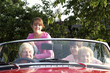An old couple taking their grandchildren for a car ride