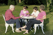 Photo : A boy and a girl talking to their grandparents in the garden A boy and a girl talking to their grandparents in the garden
