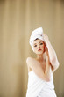 Foto: A woman with her hair and body wrapped up in towel looking at the camera A woman with her hair and body wrapped up in towel looking at the camera
