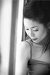 Black and white picture of a lady in spaghetti top looking down