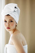 Foto: Side shot of a woman with her hair and body wrapped up in towel looking at the camera Side shot of a woman with her hair and body wrapped up in towel looking at the camera