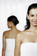 Two ladies in towels with their backs facing each other