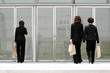 Back shot of three business women walking into a building 