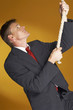Man in business suit trying to climb up a rope 