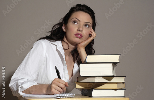 Photo: Woman sitting at her desk thinking of things to write Woman sitting at her desk thinking of things to write