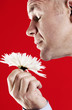 Man smelling a white flower