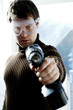 Man with goggles pointing a drill at the camera