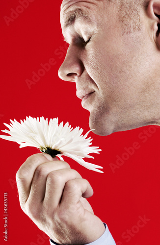 Photo: Man smelling a white flower Man smelling a white flower