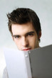 Man looking at the camera while reading book