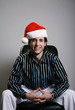 Foto: Businessman in Christmas hat smiling at the camera Businessman in Christmas hat smiling at the camera