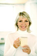 Woman holding a glass while smiling at the camera