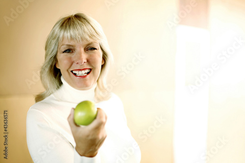 Photo: Woman holding a green apple Woman holding a green apple
