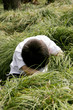 Young boy searching under the bushes